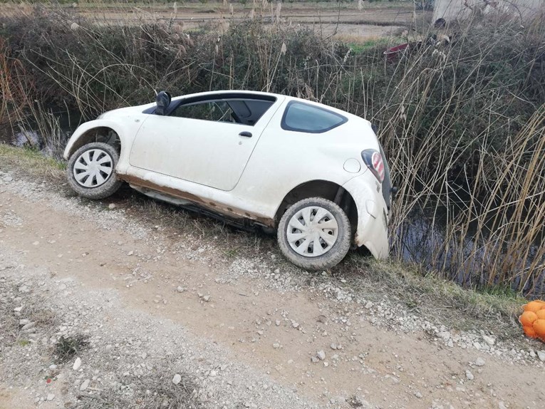 FOTO Auto u Pločama sletio s ceste i ostao visjeti nad kanalom. Putnici spašeni
